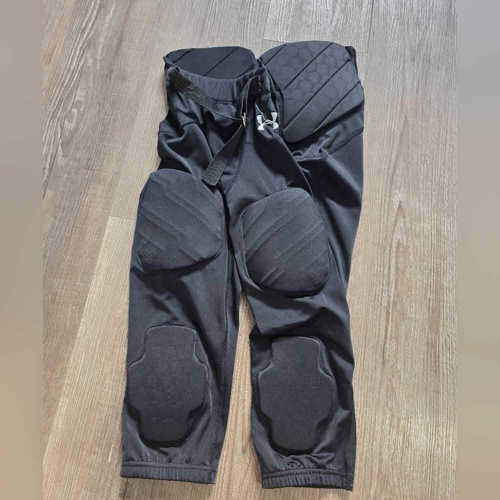 of Under Armour Gameday Integrated Padded Football Pants in black.  kids S/P